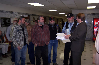 The three bikers, including Stan Strange, as well as a friend, going through legal paperwork with an attorney