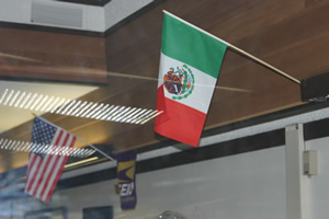 Mexican flag placed slightly above (and to the right) of "Old Glory"